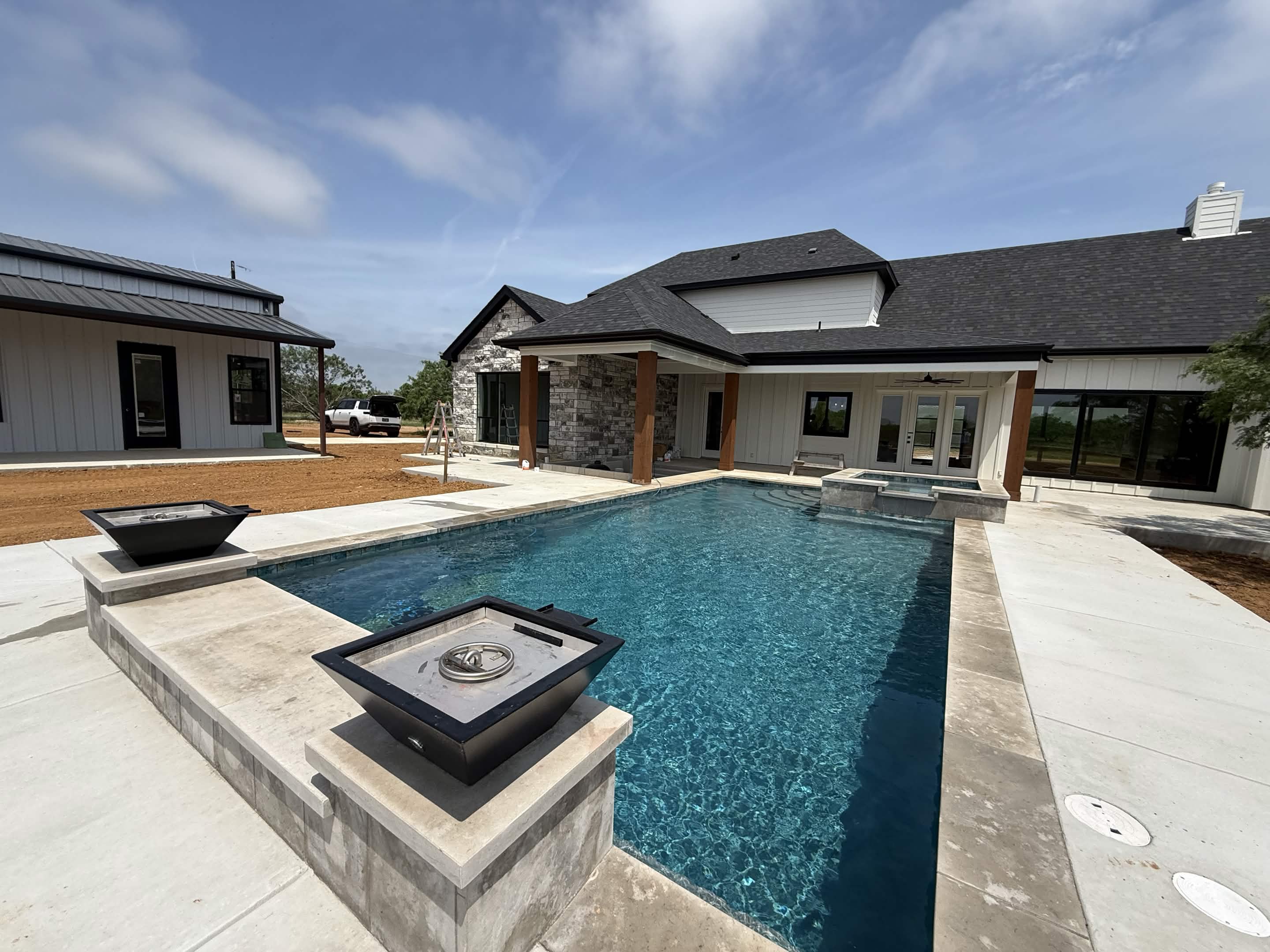 Custom pool with fire pits and modern home