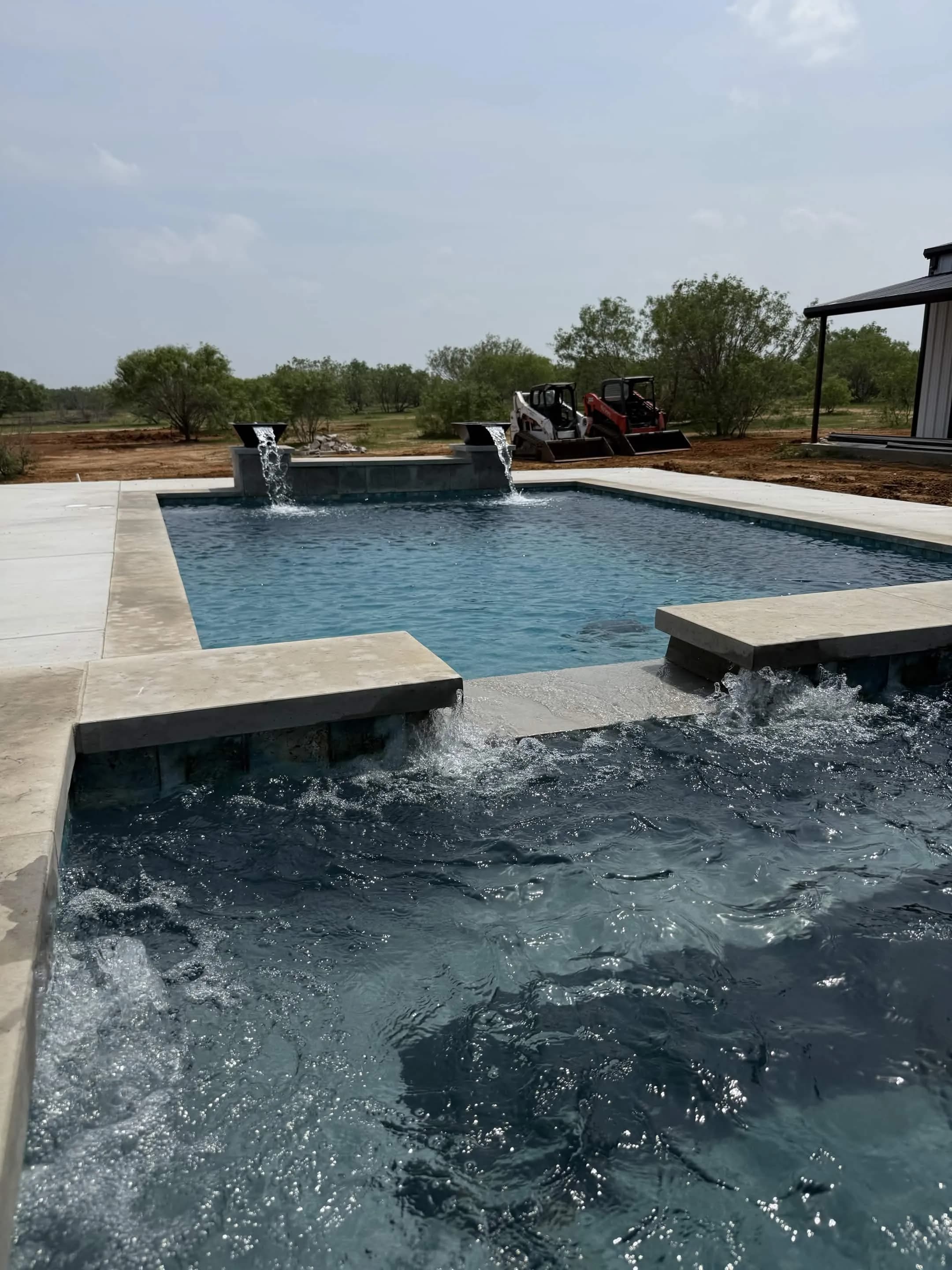 Custom gunite pool with water features and stone coping